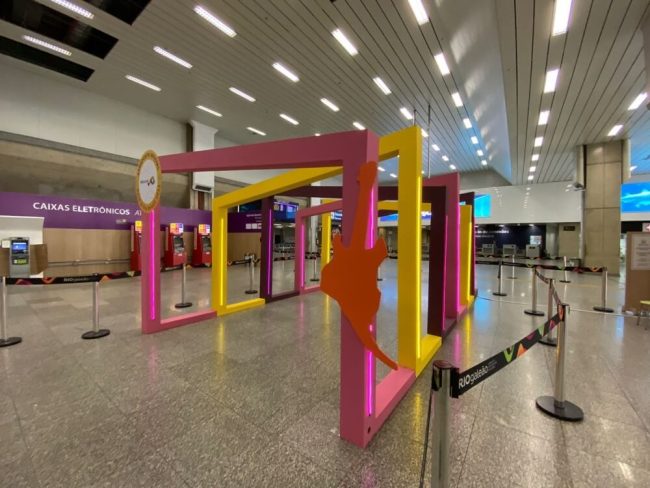 Portal de molduras rosa e amarelo no saguão do Aeroporto Rio Galeão, em ângulo aberto