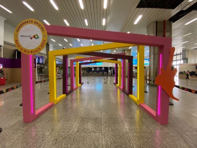 Portal cenográfico para o Rock in Rio no Aeroporto Rio Galeão, com selo circular na lateral