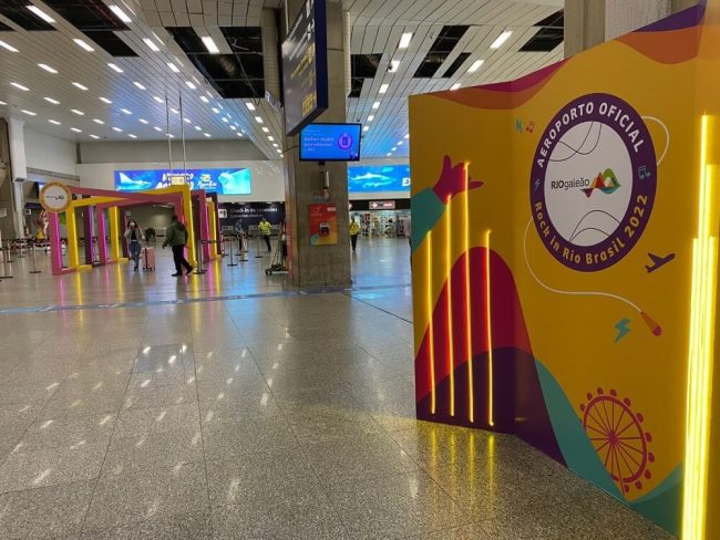 Portal cenográfico e painel de fotos colorido no saguão do Aeroporto Rio Galeão