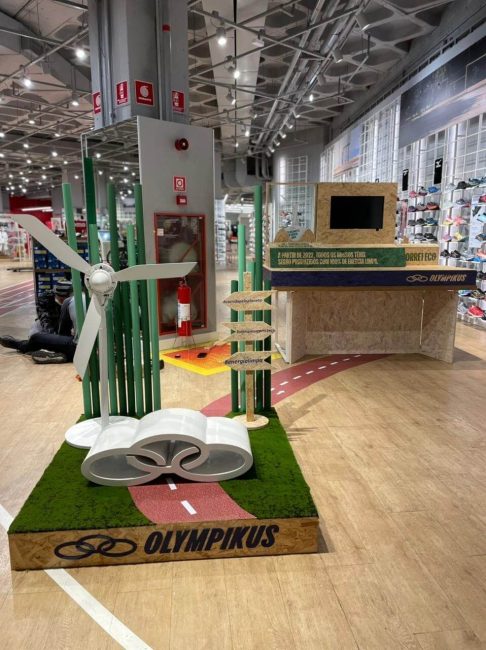 Cenografia Olympikus para ativação no ponto de venda, vista lateral com pista e placas de madeira
