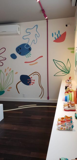 Parede com grafismos azuis e bancada com produtos Melissa na pop-up