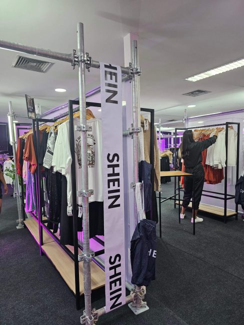 Expositor de araras em estrutura metálica com fitas Shein, projeto da pop-up em Curitiba