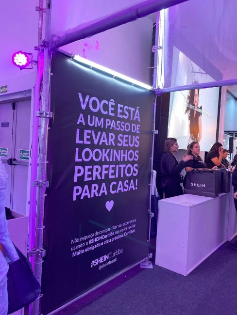 Painel preto com a frase "Você está a um passo de levar seus lookinhos perfeitos para casa"