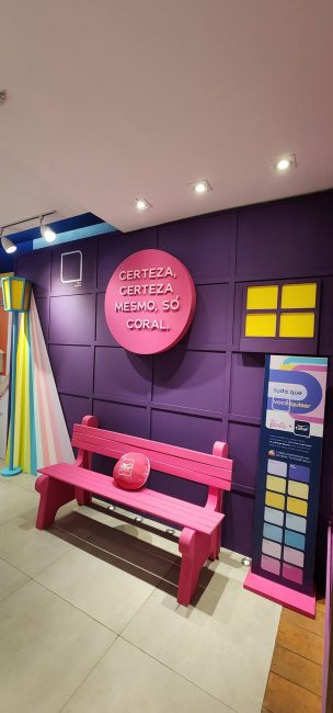 Vitrine Coral Collab Barbie: banco rosa, poste de luz e painel roxo com letreiro "Certeza, certeza mesmo, só Coral"