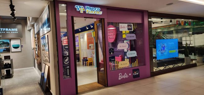 Fachada da loja Coral com vitrine Collab Barbie, vista ampla do corredor