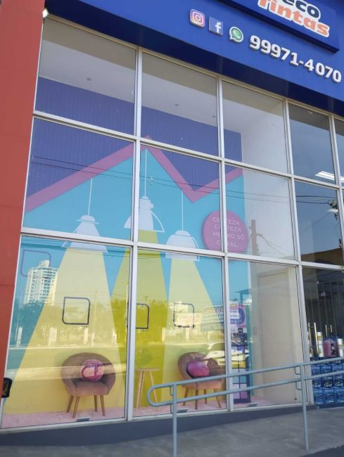 Vitrine externa Coral com adesivo de céu e feixes de luz amarelos
