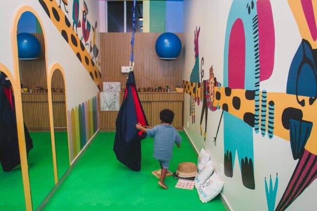 Projeto de consultório de fisioterapia infantil Kids Care – Sala com mural e atendimento